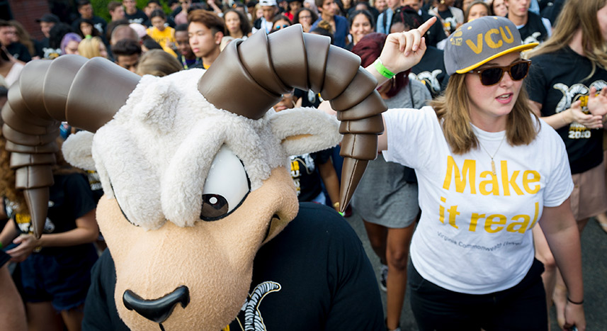 VCU mascot with student during outdoor celebration